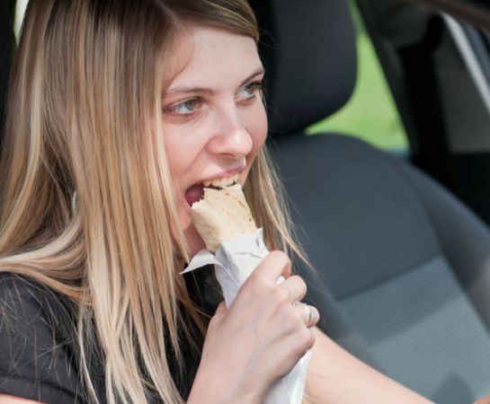девушка ест в автомобиле