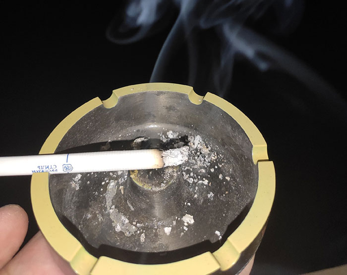 сигарета в пепельнице дымится